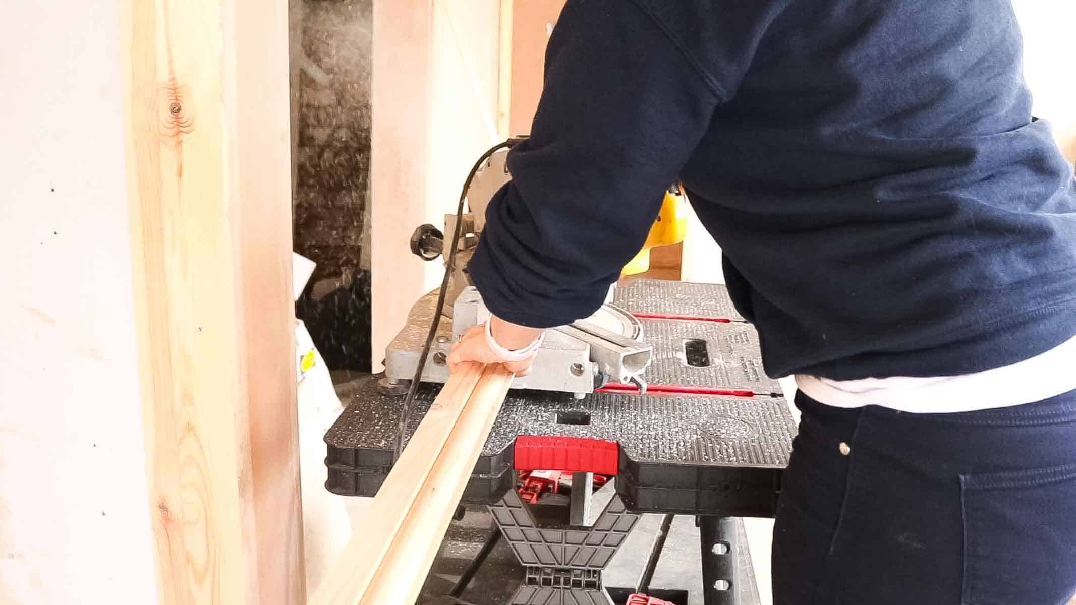 man cutting architrave in mitre box